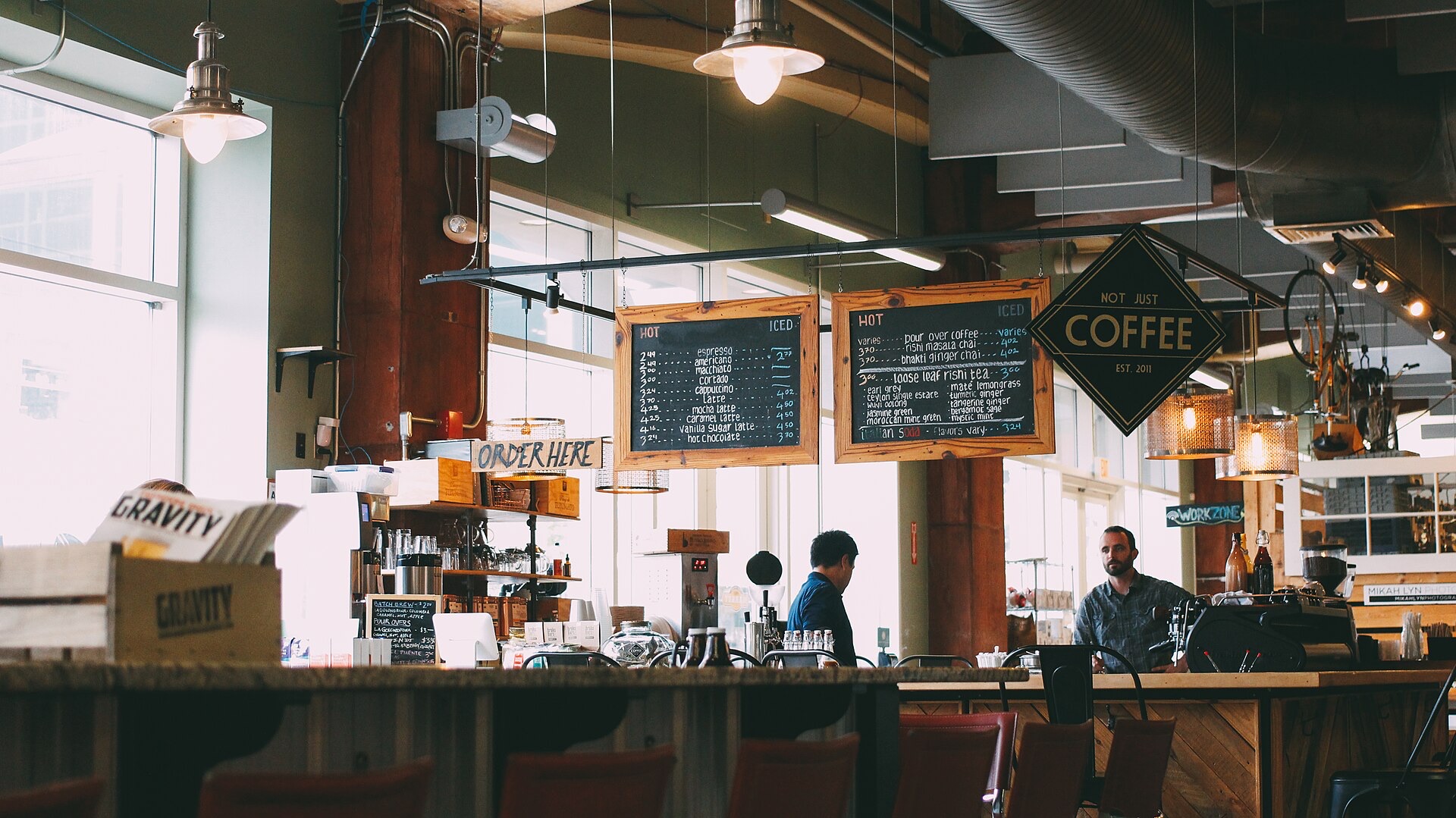 Dos personas conversan en la barra de una cafetería