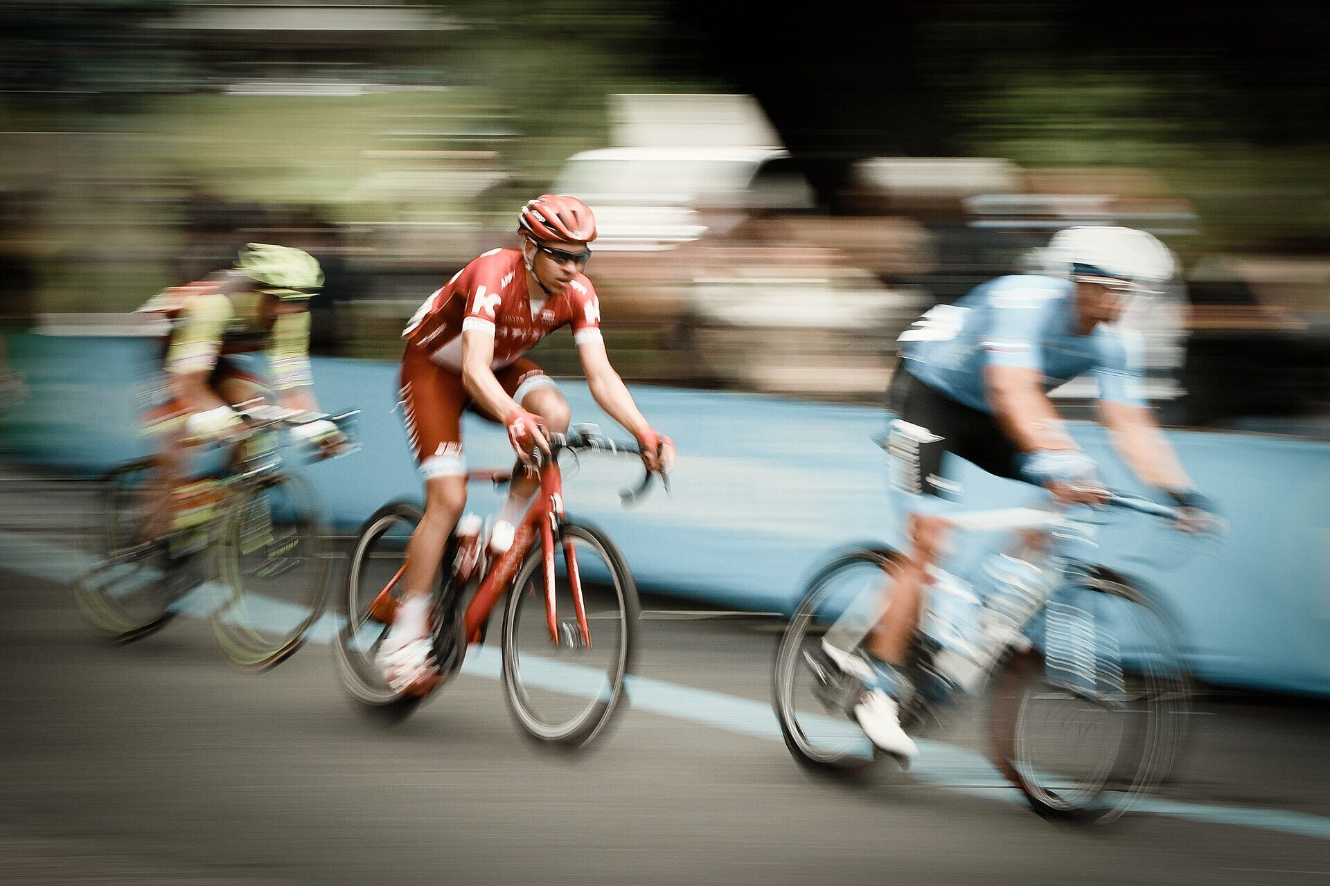 Ciclistas de ruta pedaleando a gran velocidad con fondo en movimiento