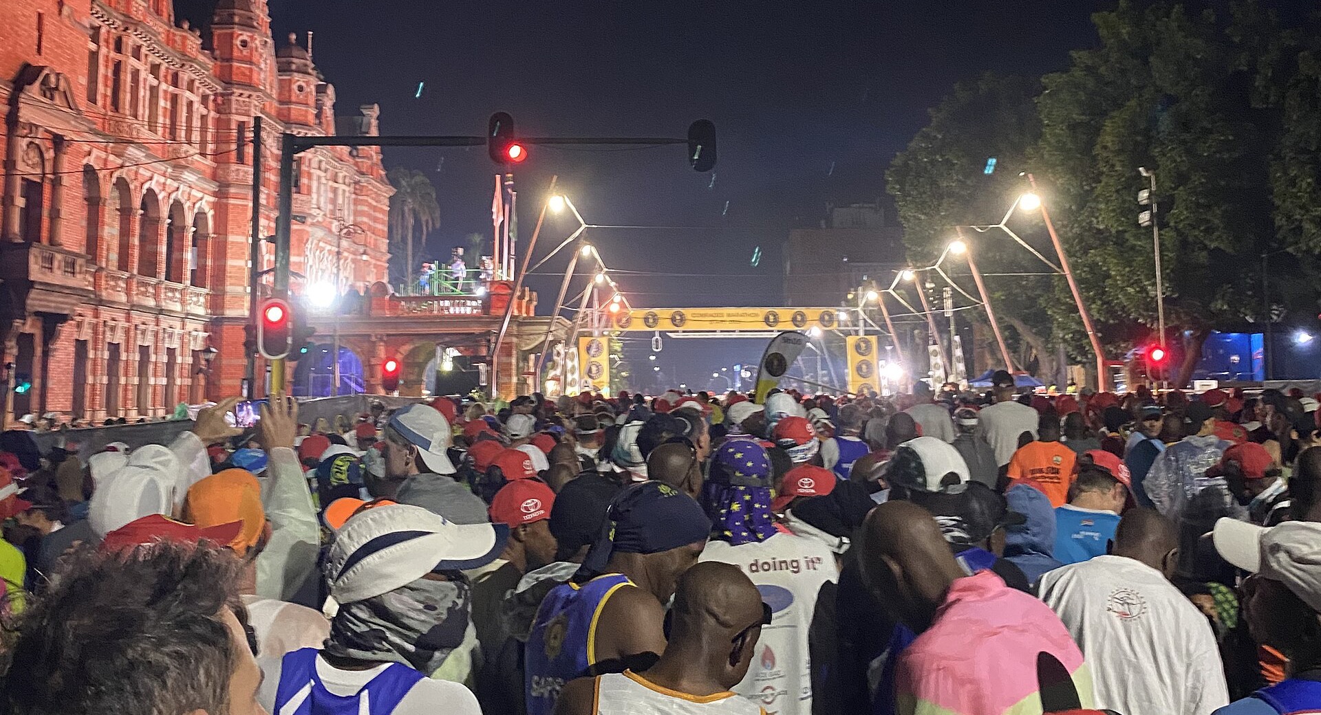 Corredores reunidos en la línea de salida de una carrera nocturna