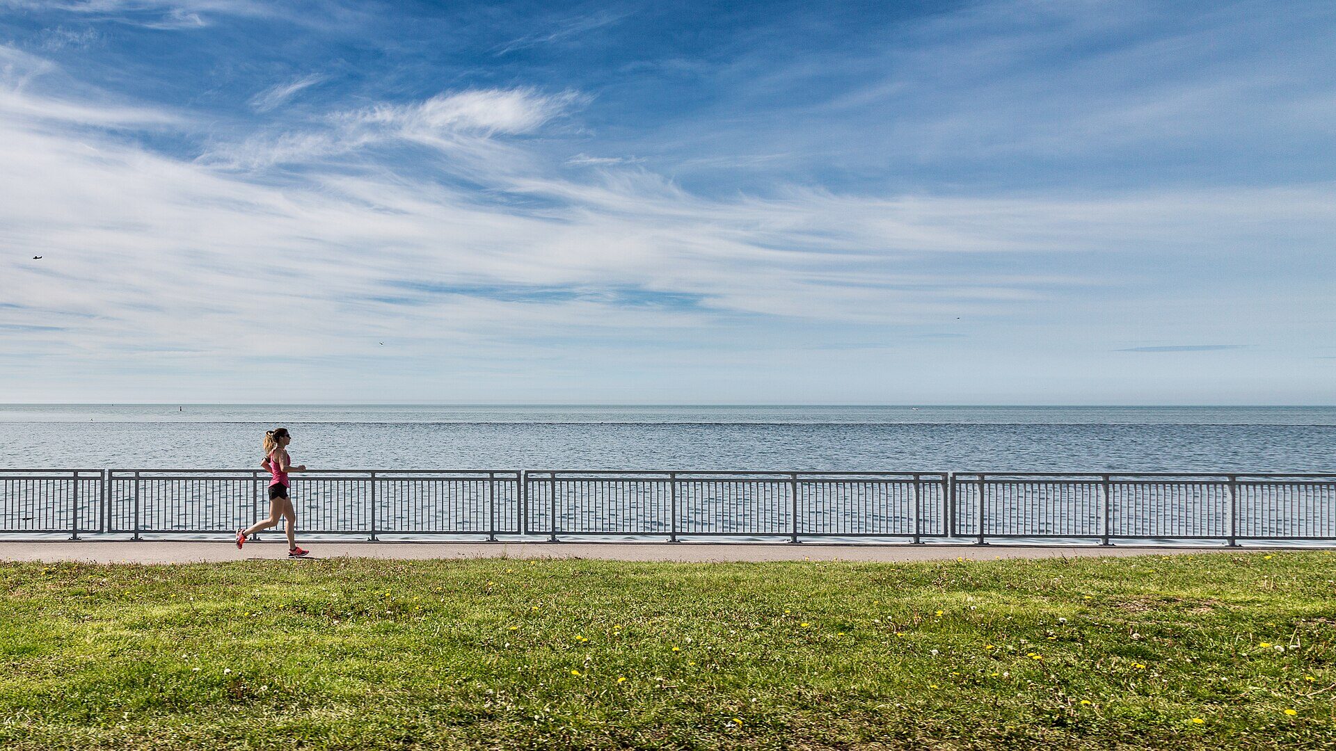 Corredor por un malecón junto al mar en la mañana