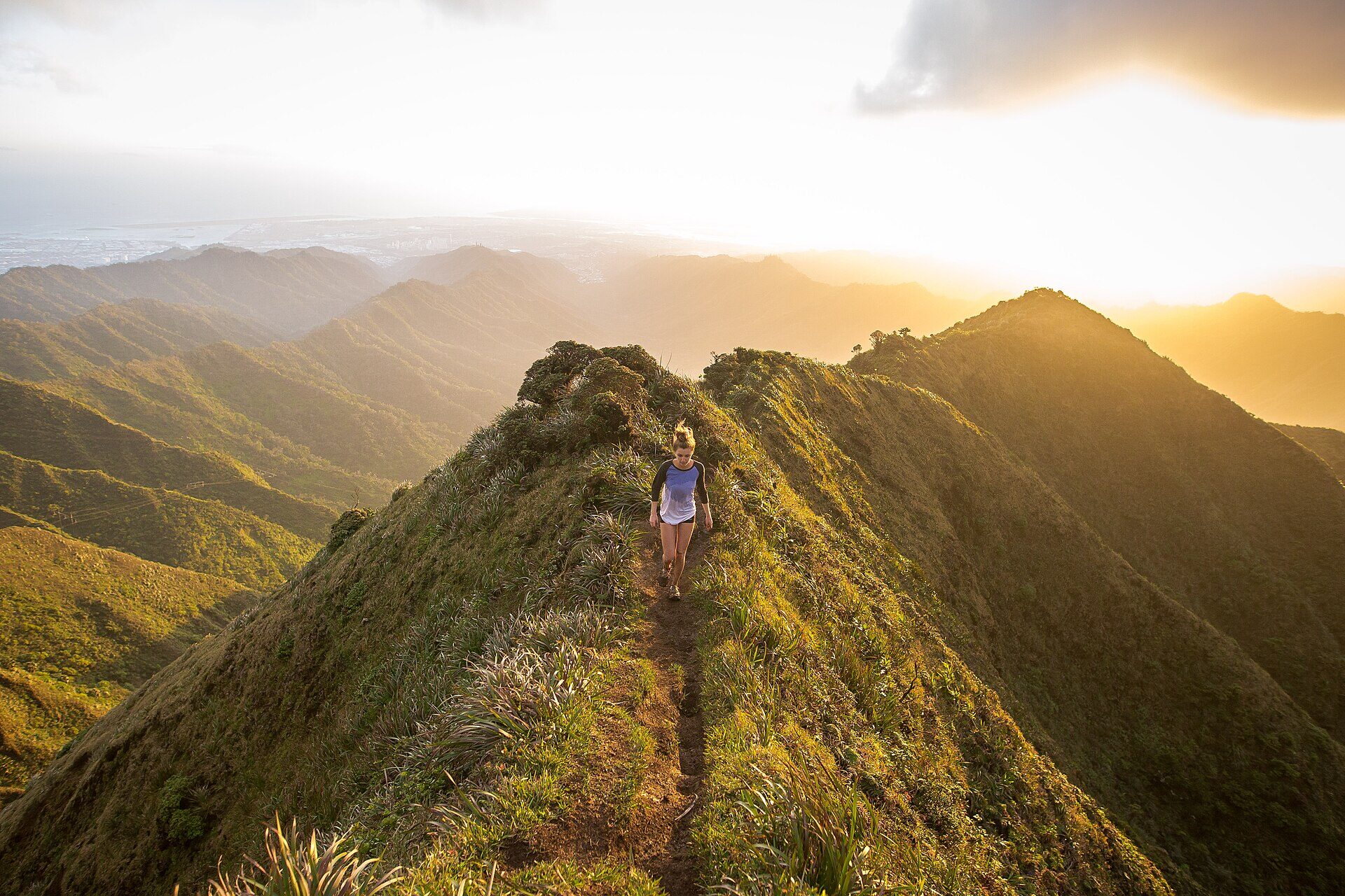 Persona caminando por la cresta de una montaña al atardecer