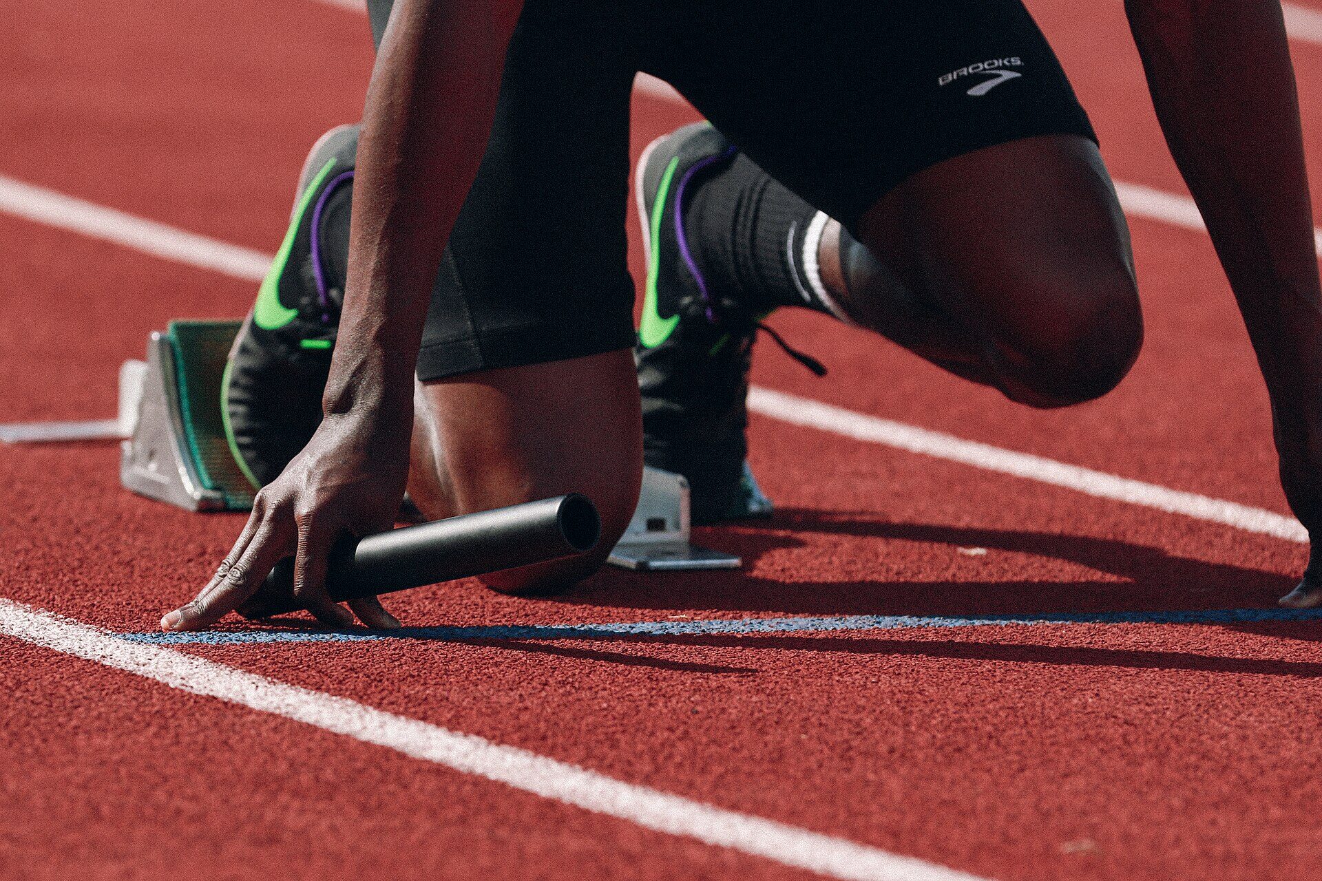 Atleta en posición de salida sobre una pista de tartán roja