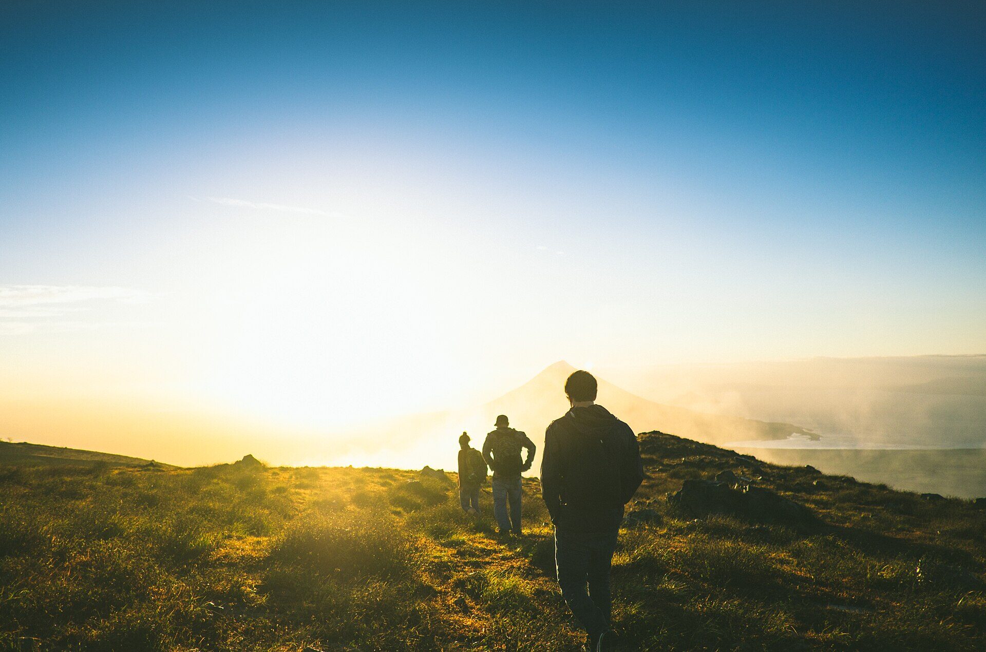 Grupo de excursionistas en la cima de un volcán al amanecer